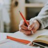 Photo by <a href="https://unsplash.com/photos/person-holding-on-red-pen-while-writing-on-book-333oj7zFsdg">
lilartsy</a>. Some rights reserved.